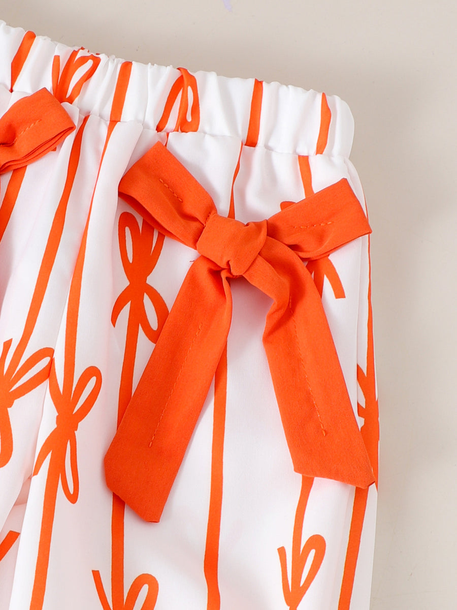 Baby pants with white cotton and orange bow pattern, featuring orange bows at the waist.