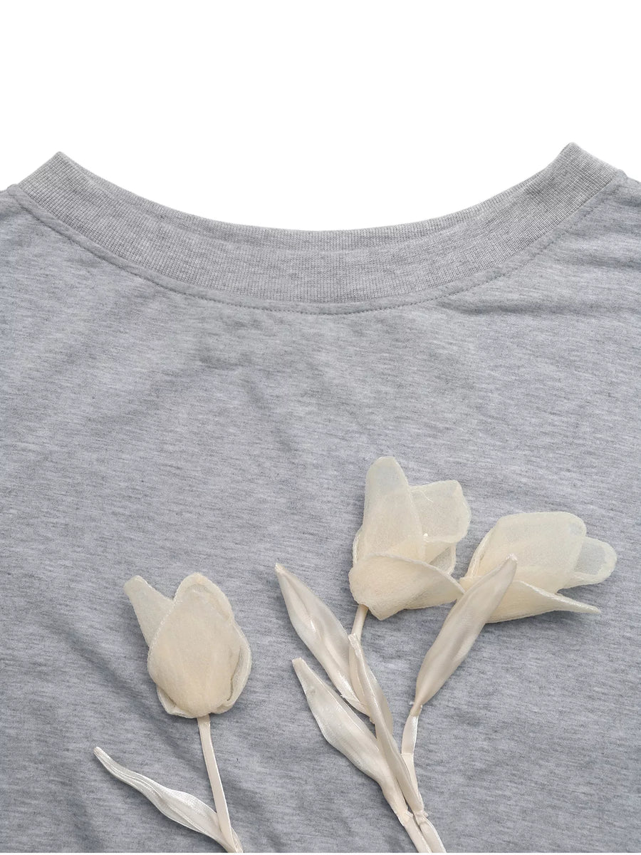Gray boat neck sweater with delicate floral applique detail.