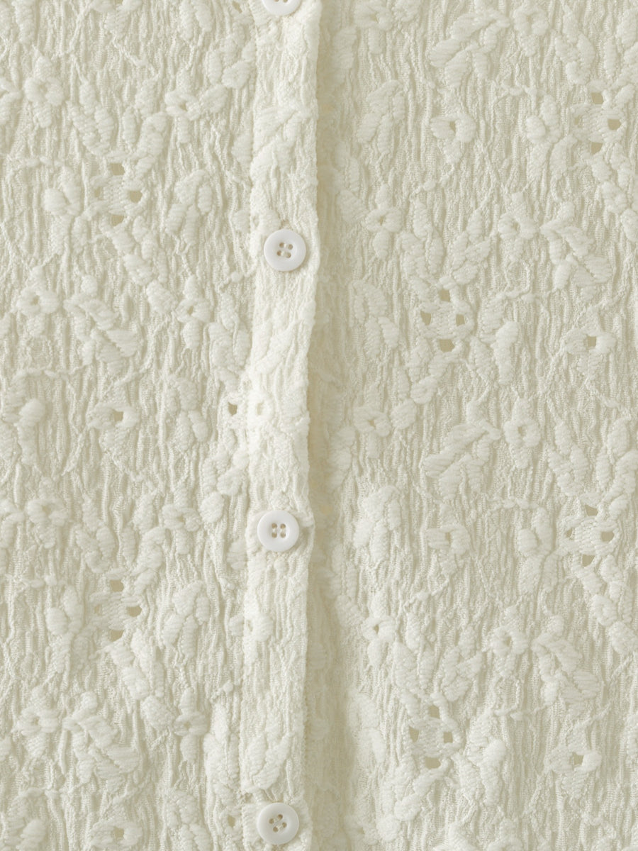 Cream lace button-up cardigan with floral texture and white buttons.