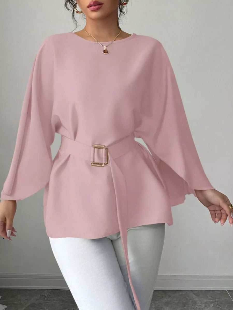 Pink belted blouse with batwing sleeves and gold buckle detail.