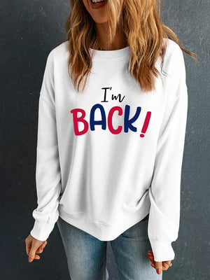 White crewneck sweatshirt with "I'm BACK!" graphic in blue and red.