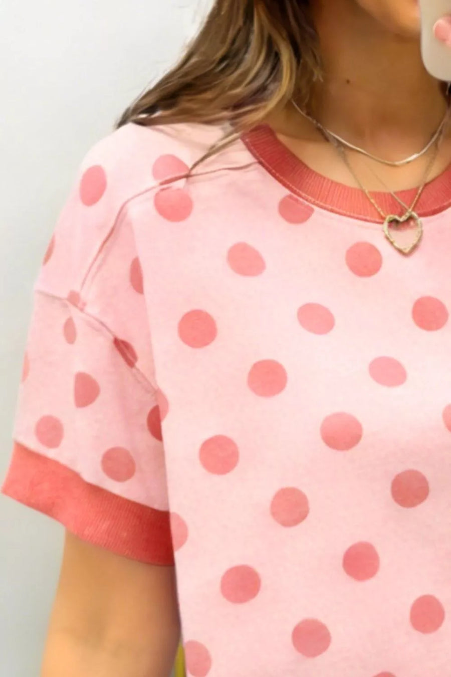 Pink polka dot short sleeve t-shirt with crew neck and contrast trim.