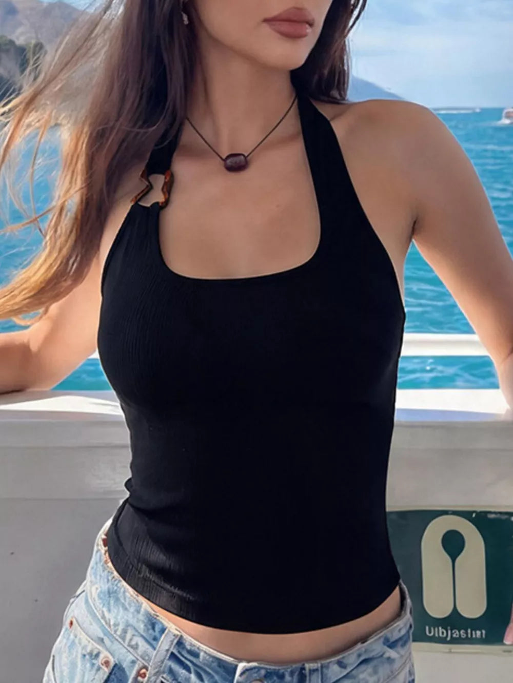 Black ribbed halter tank top with scoop neck and unique strap detail.