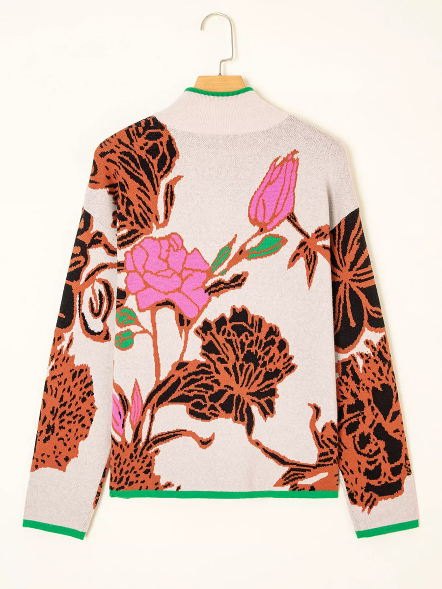 Knit quarter zip sweater in floral print with stand neck and green trim.