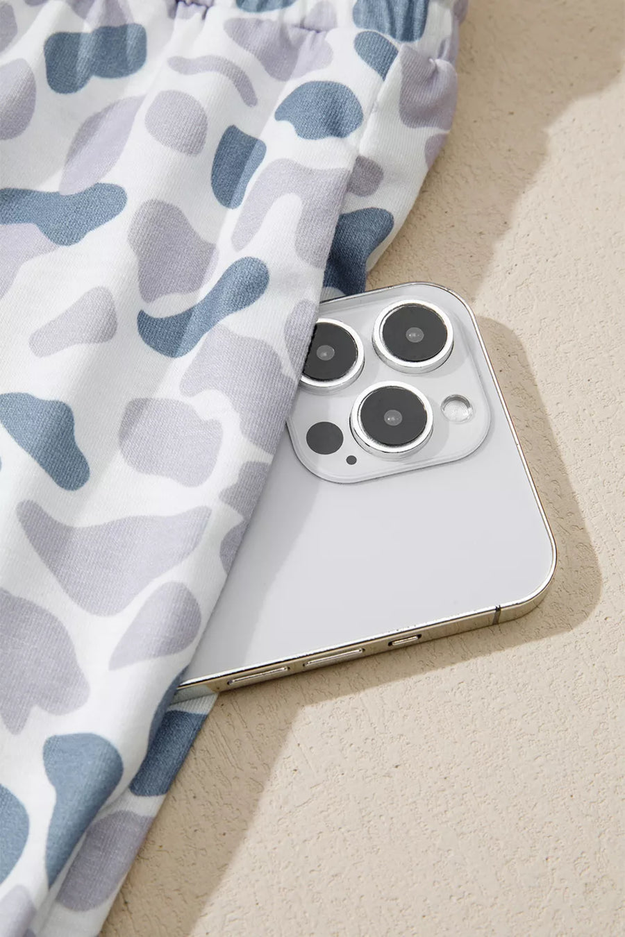 Camouflage print pajama pants in blue and grey with a white background, showing a side pocket detail.