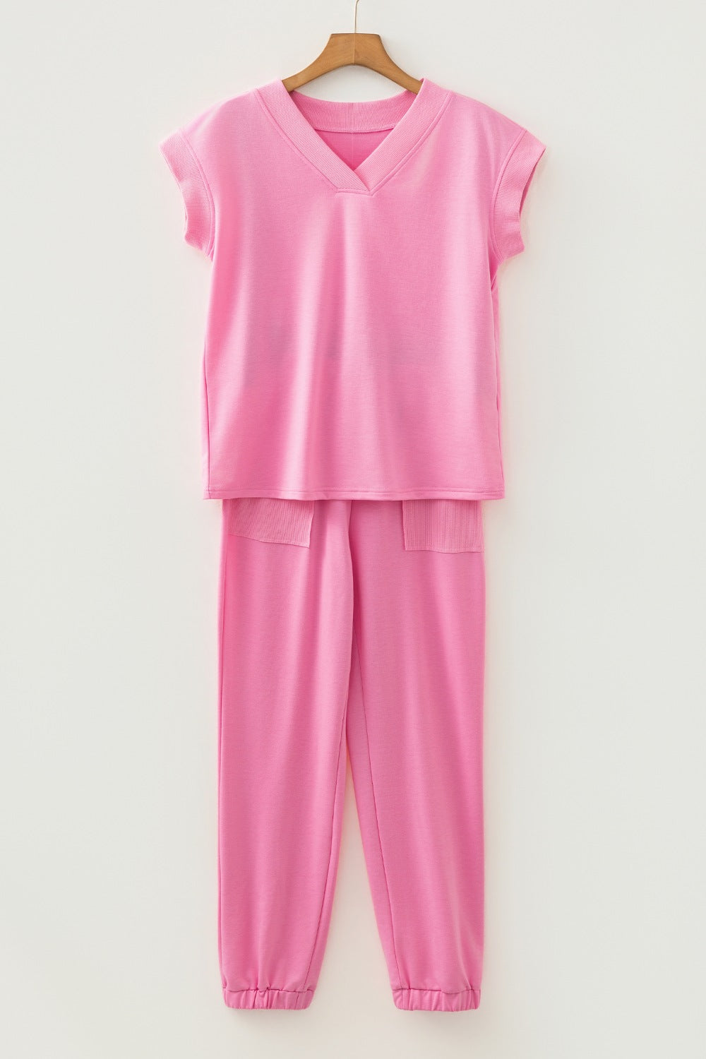 Pink cotton loungewear set with V-neck top and drawstring pants with pockets.