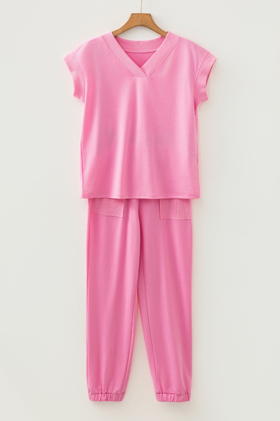 Pink cotton loungewear set with V-neck top and drawstring pants with pockets.