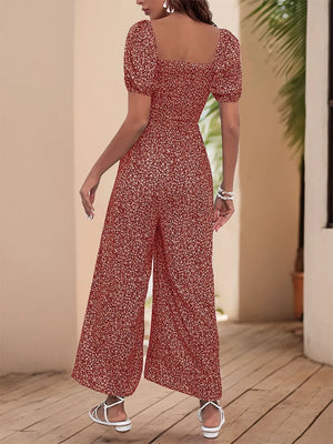 Smocked bodice puff sleeve jumpsuit in rust floral print with wide legs.