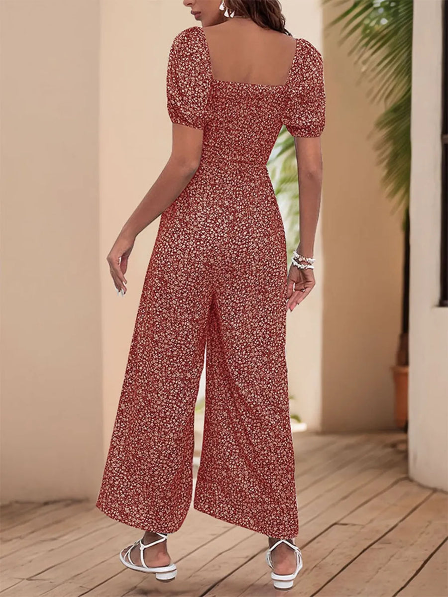 Smocked bodice puff sleeve jumpsuit in rust floral print with wide legs.
