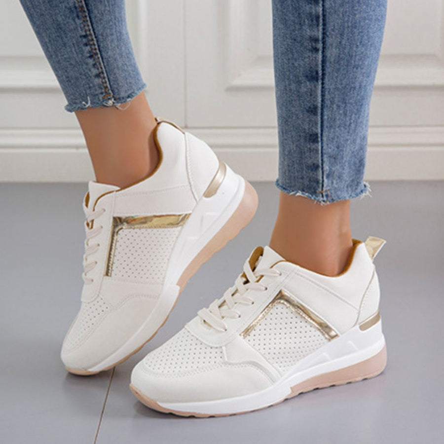 White lace-up wedge sneakers with metallic accents and perforated details.