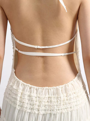 White halter dress with ruffled tiered skirt and open back with adjustable straps