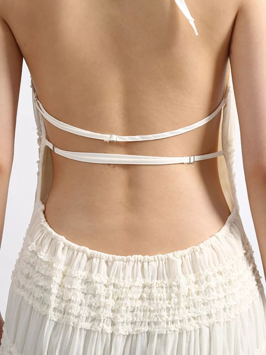 White halter dress with ruffled tiered skirt and open back with adjustable straps