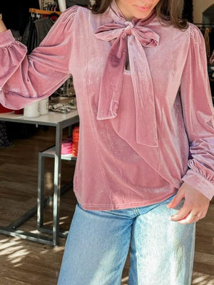 Dusty pink velvet blouse with tie-neck and puff sleeves.