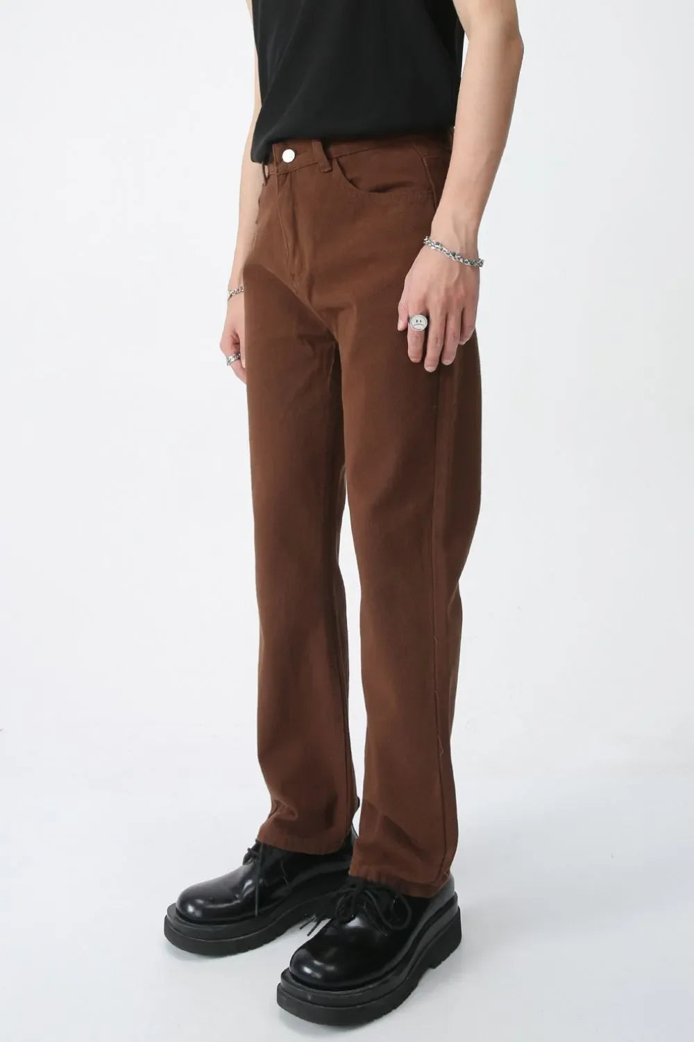 Relaxed fit chino trousers in chocolate brown, styled with a black t-shirt and platform shoes.