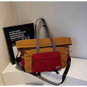 Colorblock tote bag with red front pocket and grey straps