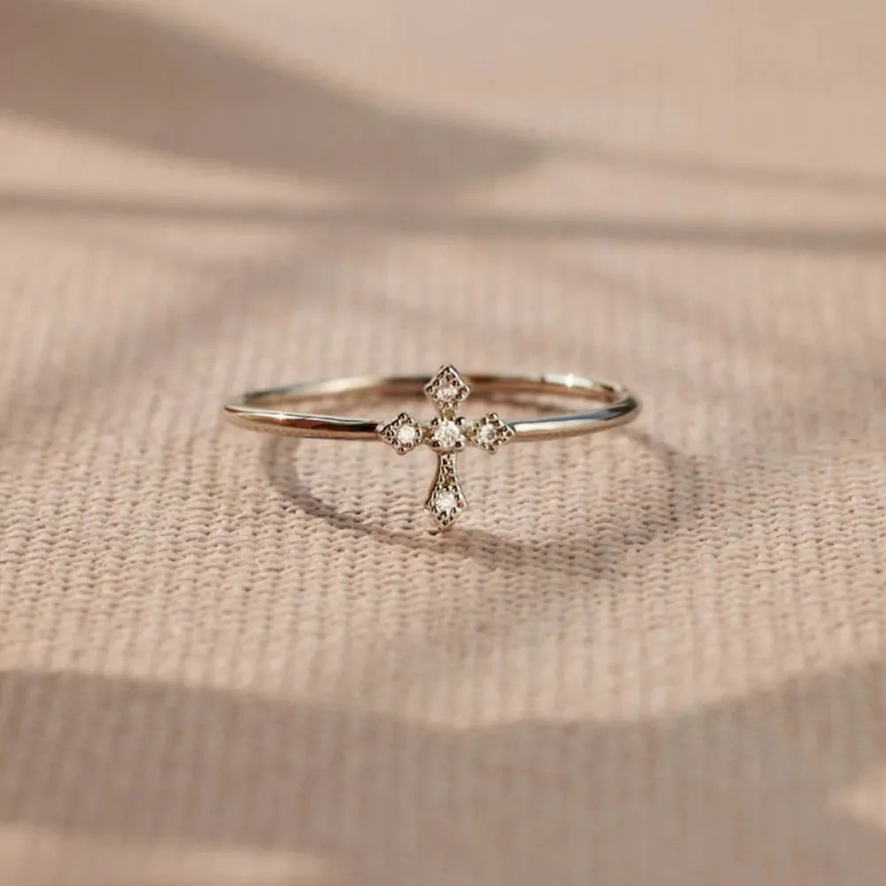 Delicate diamond cross ring in silver with sparkling cubic zirconia accents.