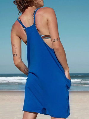 Blue linen blend romper with striped straps and pockets, styled with a bikini top.