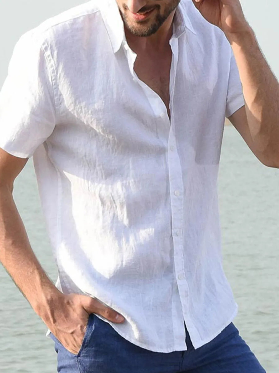 White linen resort shirt with short sleeves and button front, styled with blue jeans.