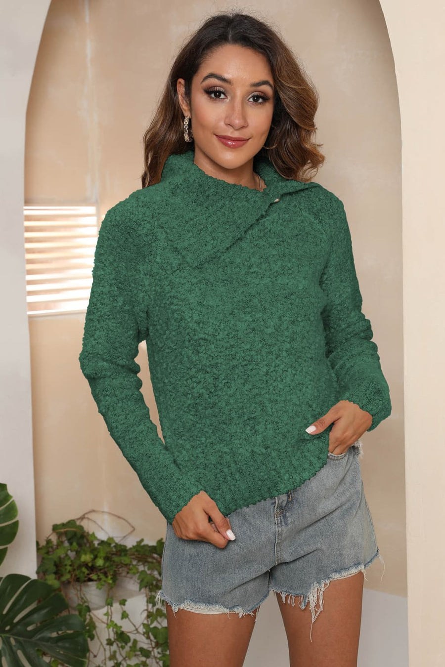 Dark green textured knit sweater with an asymmetric collar and button detail.