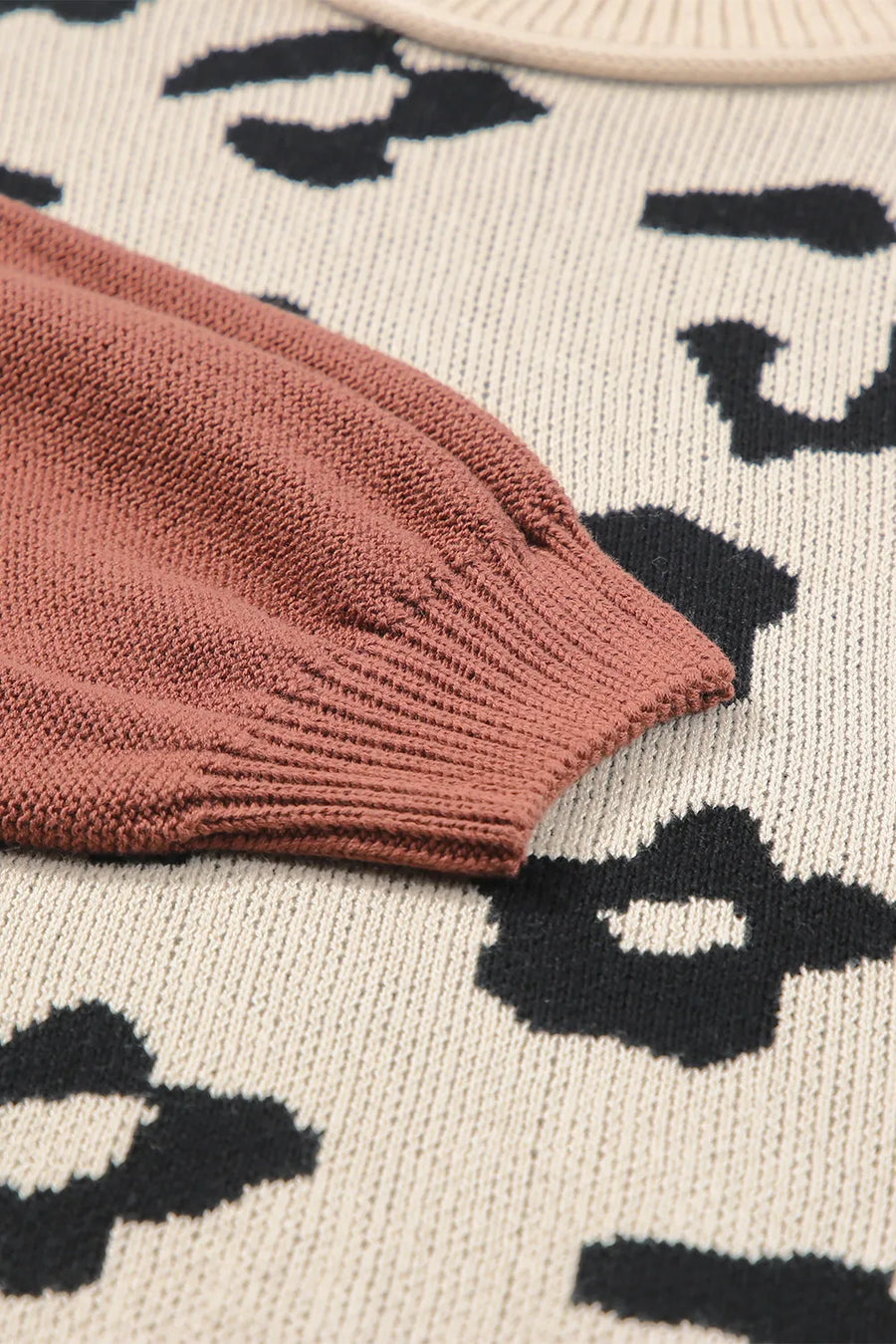 Colorblock leopard print knit sweater with a rust sleeve detail.