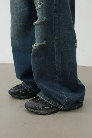 Distressed baggy denim jeans in dark wash with ripped details.