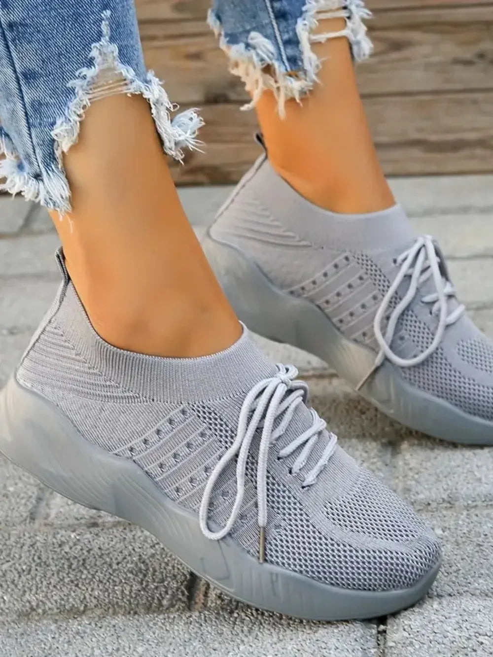 Gray knit runner sneakers with sculpted sole and white laces.