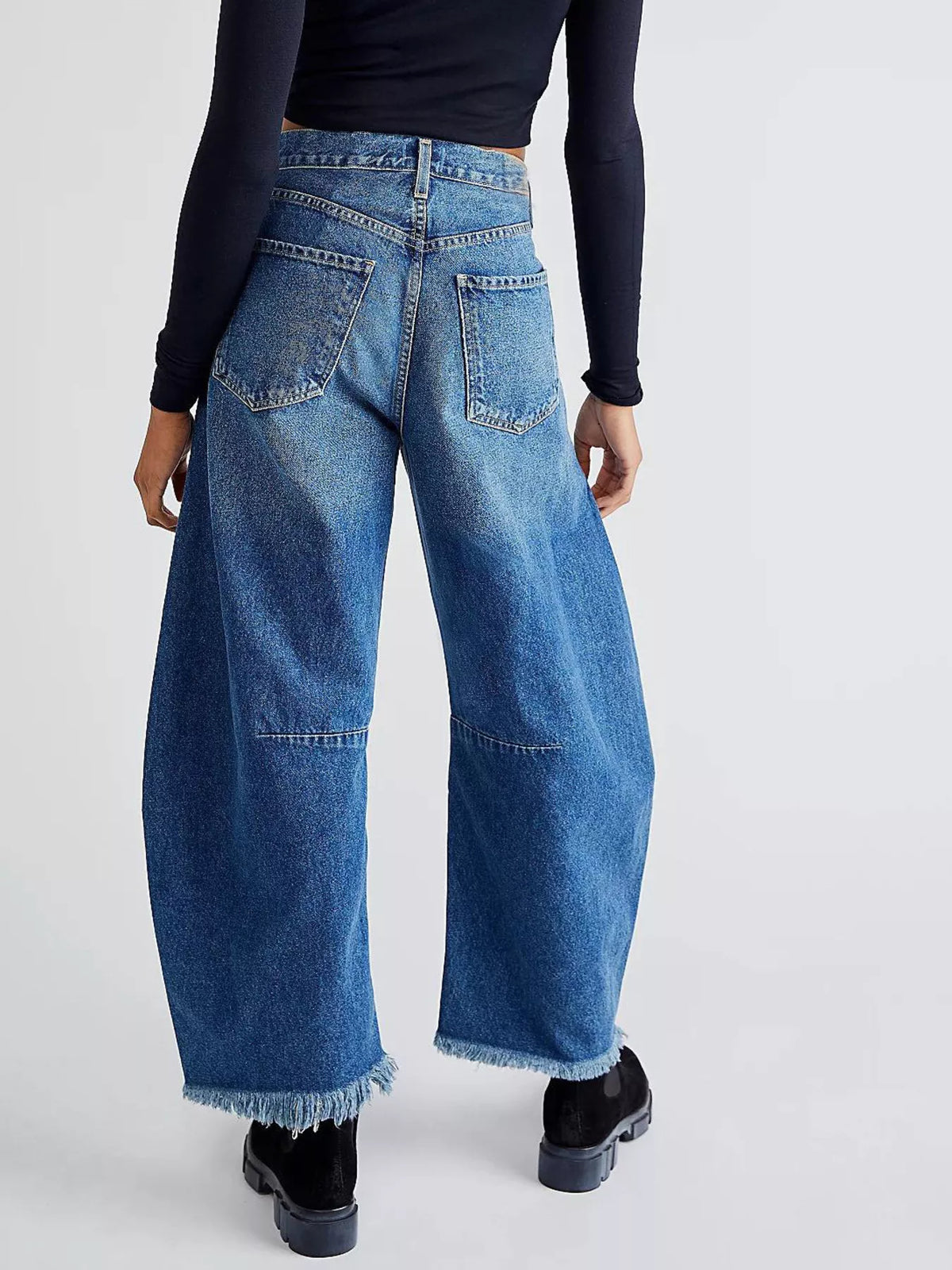 Blue denim wide-leg trousers with raw hem and paneled knees.