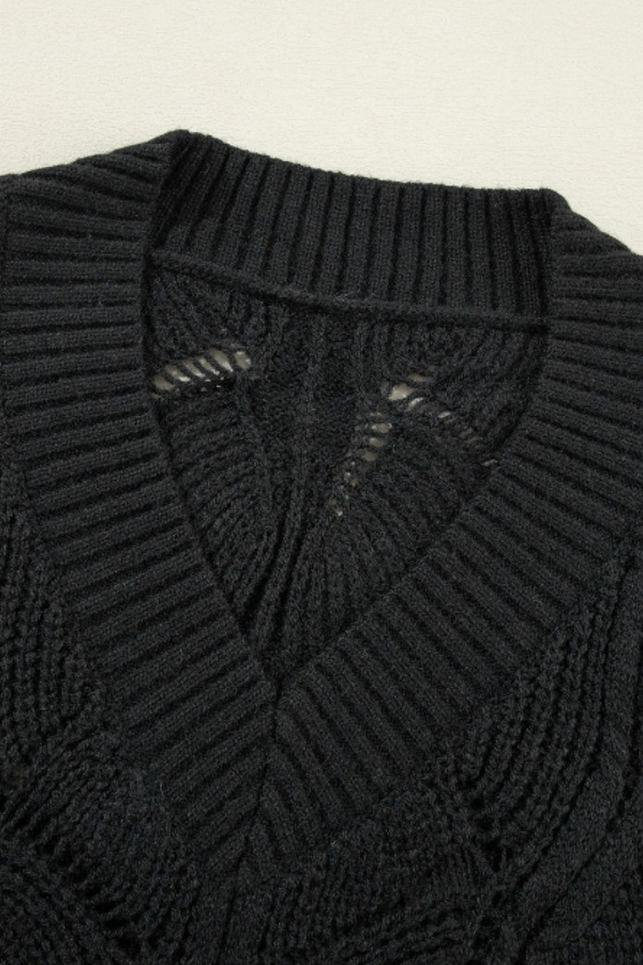 Black openwork knit V-neck pullover sweater with textured stitch details.