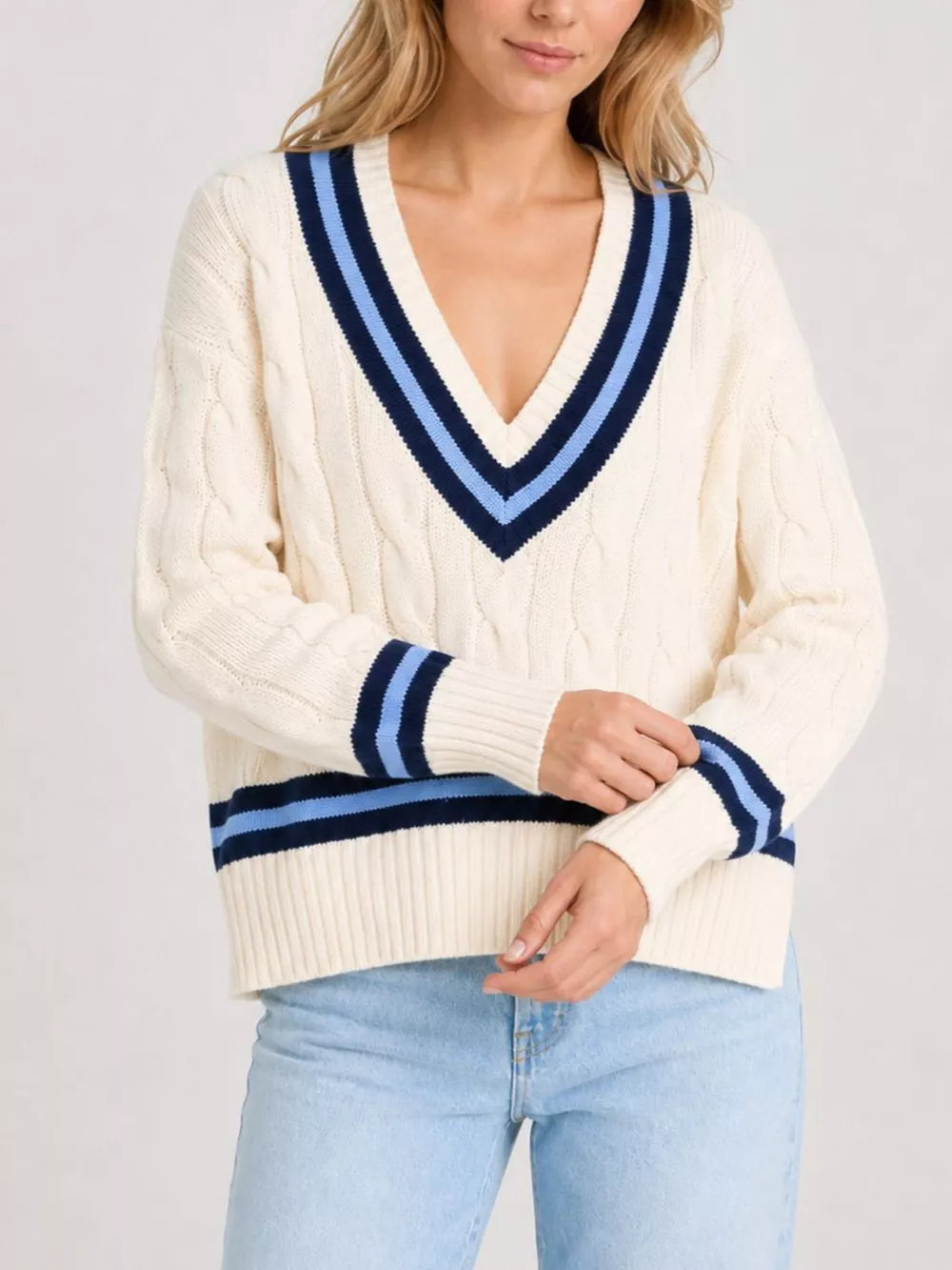 Cream v-neck sweater featuring cable-knit and cable knit