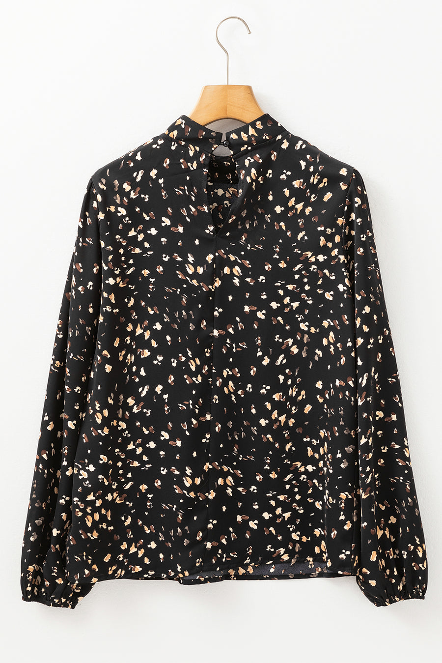 Black high-neck abstract print blouse with long sleeves and button closure at back neck.