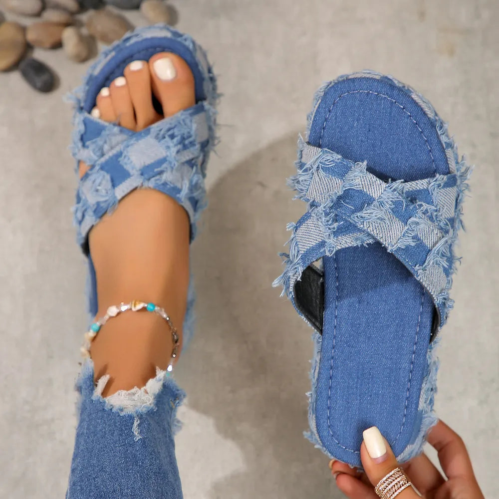 Distressed denim checkered platform slides with crisscross straps and frayed edges.