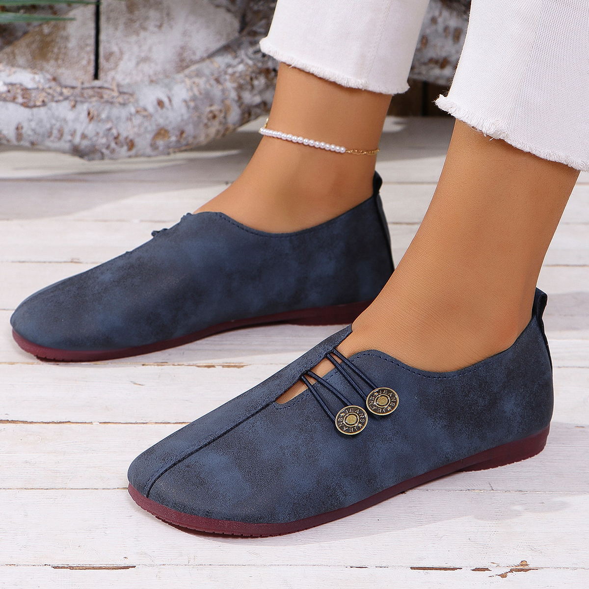 Blue round-toe casual flats with decorative buttons and elastic straps.