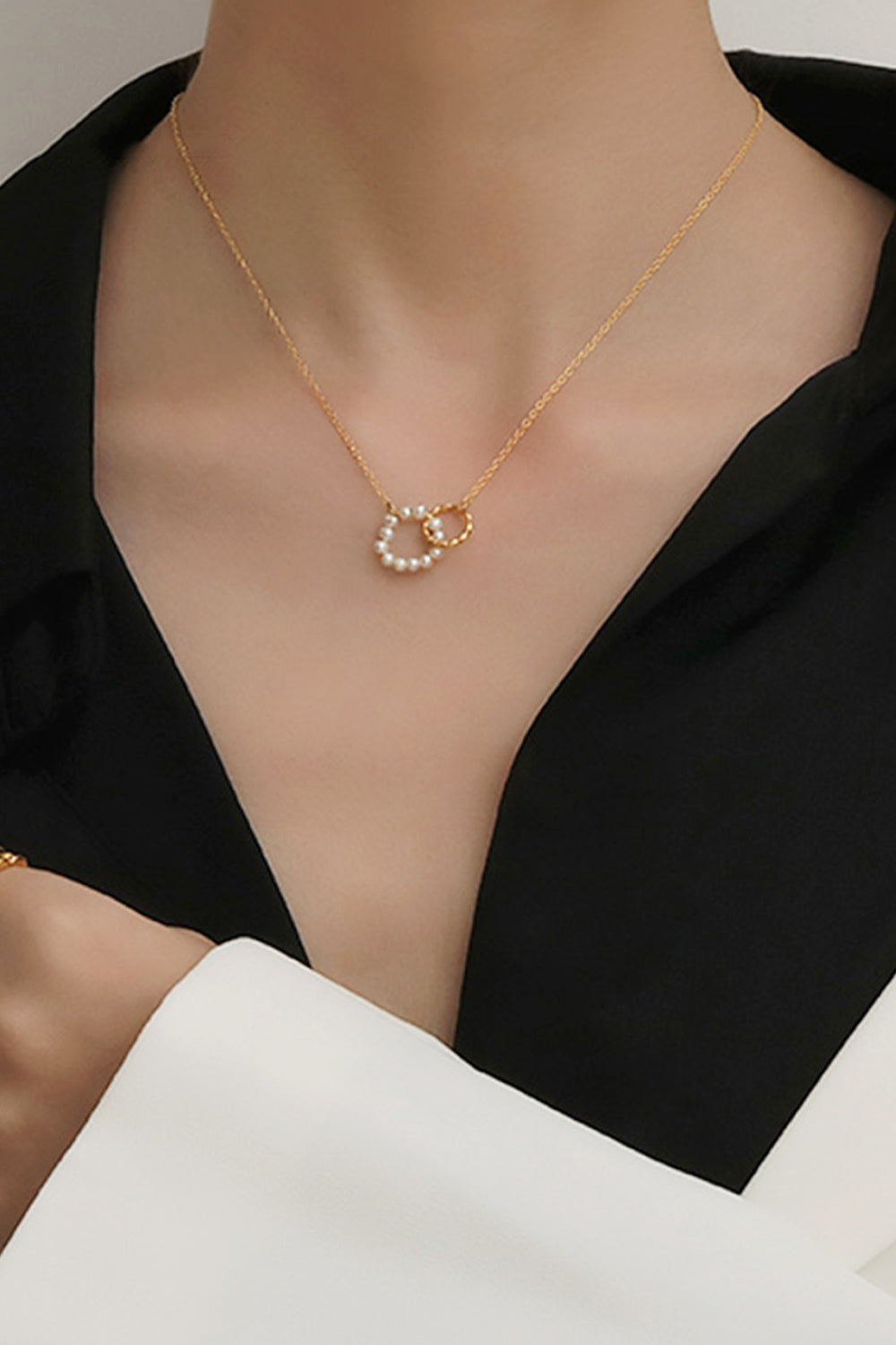 Gold-plated necklace with interlocking pearl and textured circles pendant