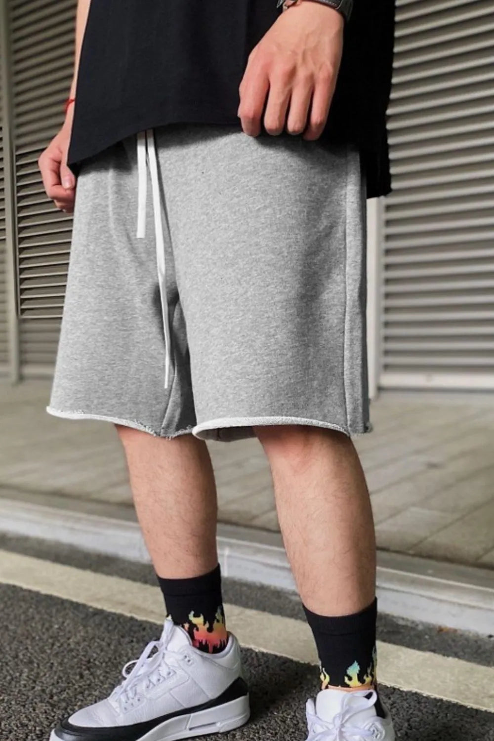 Gray relaxed fit jogger shorts with raw edges and white drawstring