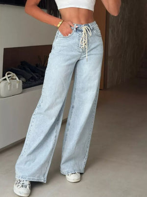 Light wash denim jeans with a lace-up high waist and wide leg