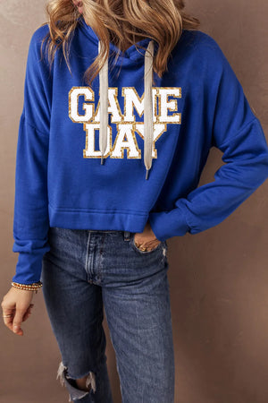 Royal blue cropped hoodie with glitter "GAME DAY" graphic and adjustable drawstring hood.