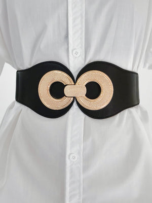 Black cincher belt with gold metalwork detail, worn over a white shirt.