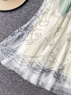 Off-white tulle skirt with abstract sunburst print and pleated hem detail.