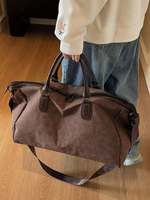 Chocolate duffel bag with adjustable strap and leather handles