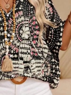 Bohemian print V-neck t-shirt in black with pink accents, featuring a tassel necklace.