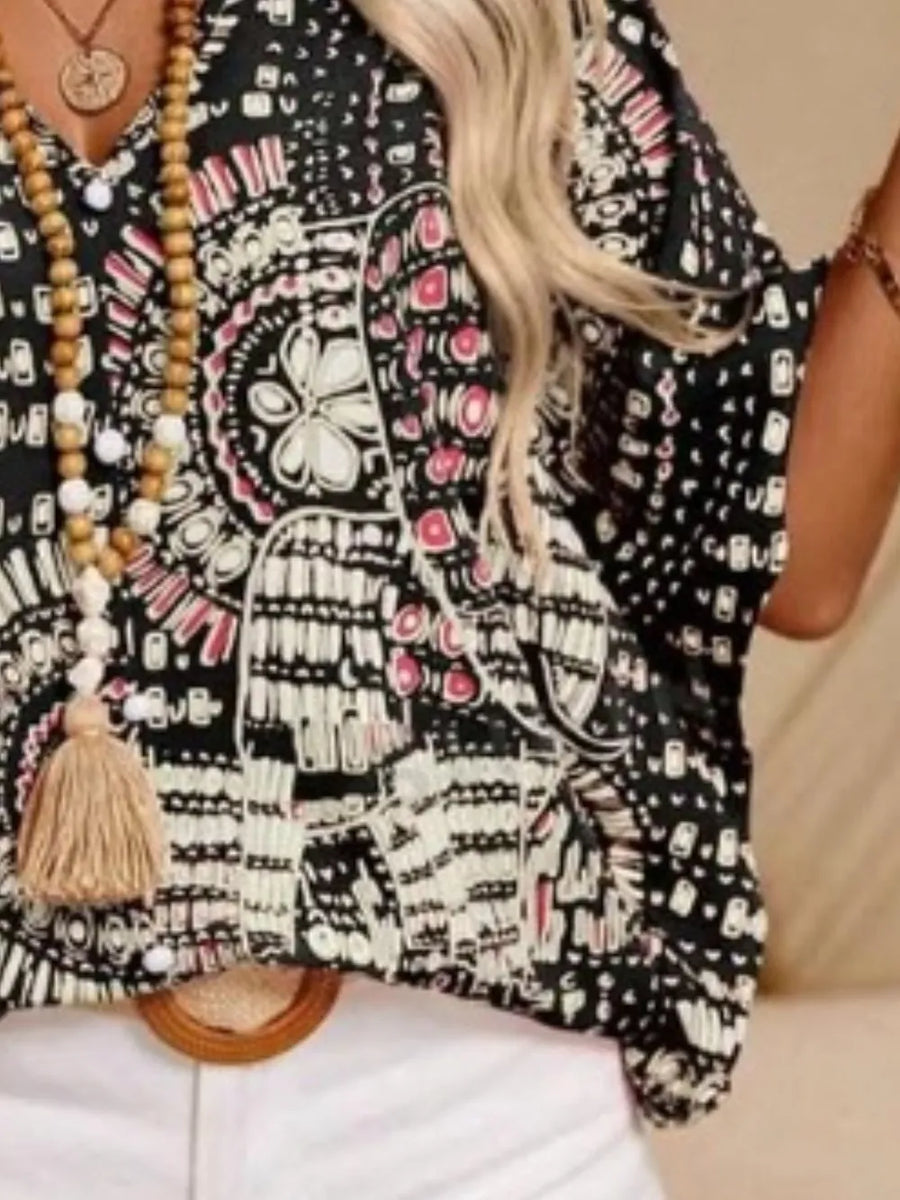 Bohemian print V-neck t-shirt in black with pink accents, featuring a tassel necklace.