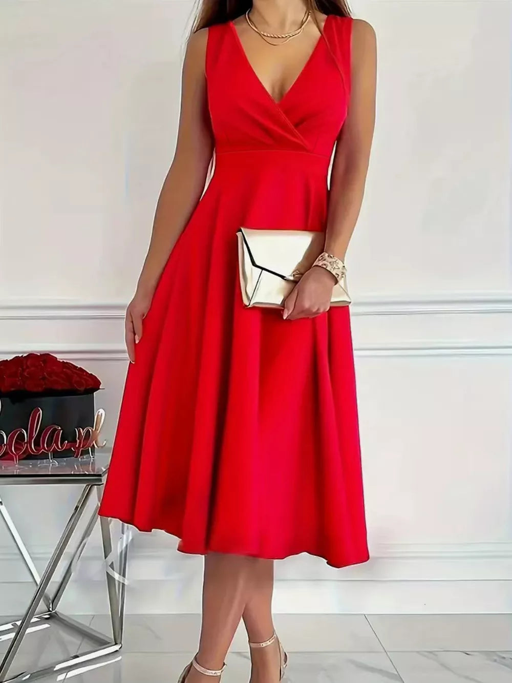 Red A-line midi dress with V-neck and sleeveless design, styled with a clutch.