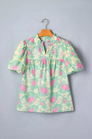 Pastel floral print polyester blouse with ruffled neckline and puff sleeves.
