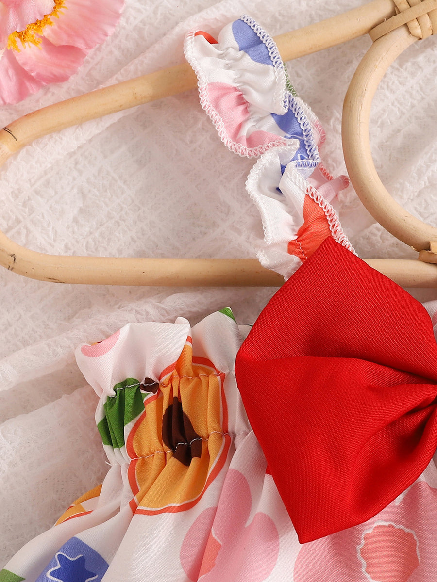 Fruit print bikini set with ruffled straps and a red bow detail.