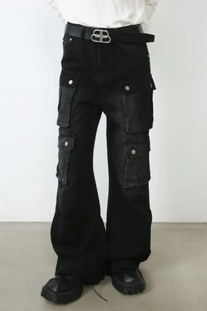 Dark oversized denim cargo pants with multiple pockets and a flared leg.