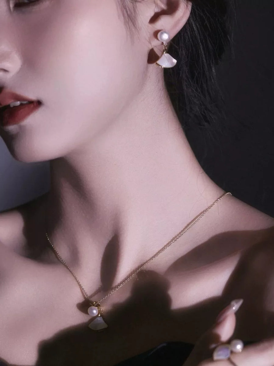Elegant fan-shaped pearl earrings with white shell accents and a delicate gold chain necklace.