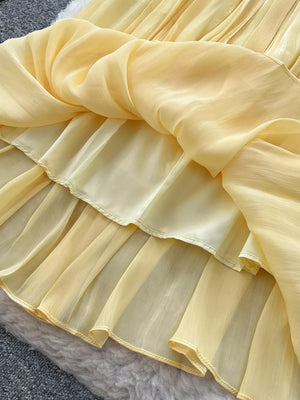 Yellow pleated maxi skirt with sheer overlay and ruffled hem detail