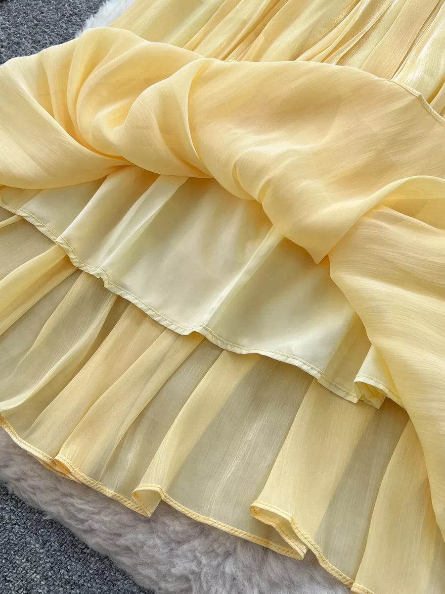 Yellow pleated maxi skirt with sheer overlay and ruffled hem detail