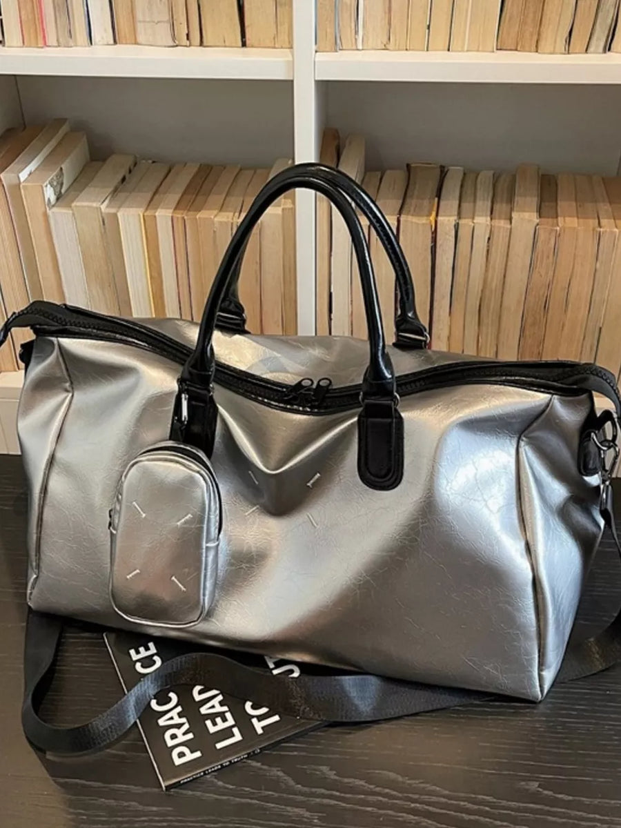 Sleek silver metallic large travel bag with black handles and adjustable strap.