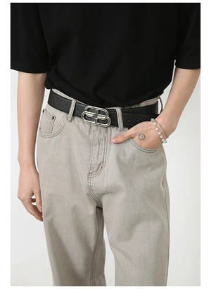 Gray wide-leg denim trousers with seam detail and a silver buckle belt.